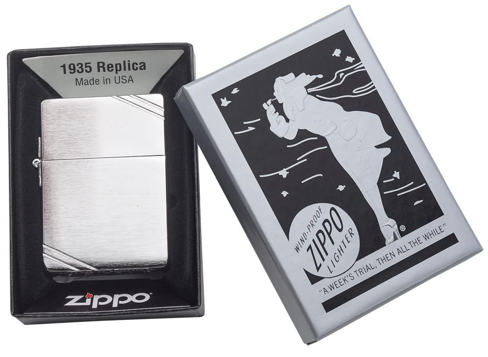 Zapalniczka Zippo 1935 replika z przodu w kolorze szczotkowanego chromu z wygrawerowanymi ukośnikami na przeciwległych rogach, w otwartym czarnym szarym pudełku upominkowym