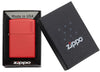 Widok z przodu zapalniczka Zippo Red Matte z logo Zippo otwarta z płomieniem w otwartym opakowaniu prezentowym