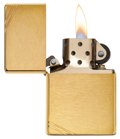 Widok z przodu zapalniczka Zippo Vintage Brass Brushed z ozdobnymi ukośnymi kreskami w obu narożnikach otwarta z płomieniem