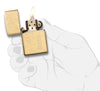 Widok z przodu zapalniczka Zippo High Polish Brass ze wzorem weneckim i płytką na inicjały otwarta z płomieniem w stylizowanej dłoni