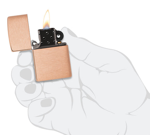 Model podstawowy zapalniczki Zippo z litej szczotkowanej miedzi i czarnym wkładem, otwierany płomieniem w stylizowanej dłoni