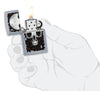 Zapalniczka Zippo chrom czaszka ze złudzeniem optycznym otwarta z płomieniem w stylizowanej dłoni