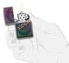 Widok z przodu zapalniczka Zippo Iridescent Matte z pieczątką z logo Zippo wygrawerowaną laserowo otwarta z płomieniem w stylizowanej dłoni