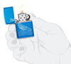 Zapalniczka Zippo z przodu otwarta i zapalona Whale Design błyszczący jasnoniebieski z wygrawerowanym wielorybem z okrągłymi falami w stylizowanej dłoni